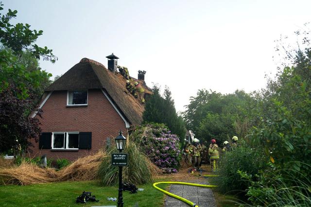 Vermoedelijke blikseminslag zorgt voor brand in een rietgedekte woning aan de Molenweg in Giethoorn
