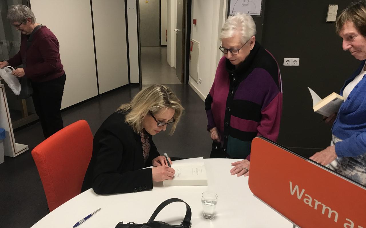 Schrijfster Judith Koelemeijer signeert in de pauze de zojuist door aanwezigen aangekochte boeken. Bijzonder is dat in de zaal waar zij haar lezing houdt, ook een gedenksteen staat van Julia de Vries, de directrice van de bibliotheek Steenwijk die op 20 november 1943 bij Auschwitz om het leven werd gebracht.