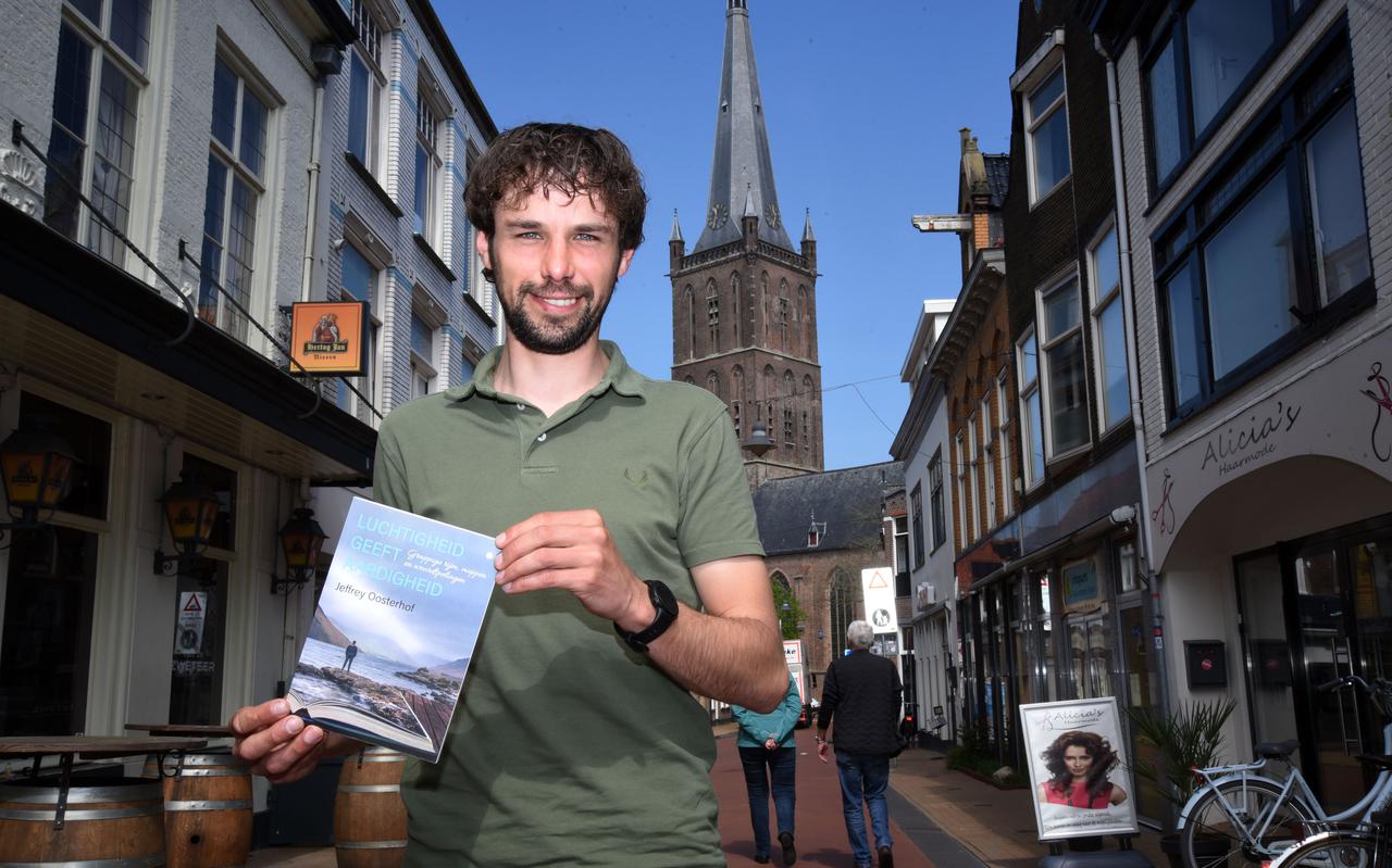 Jeffrey Oosterhof poseert trots met zijn boek 'Luchtigheid geeft aardigheid' onder de Steenwijker Toren.