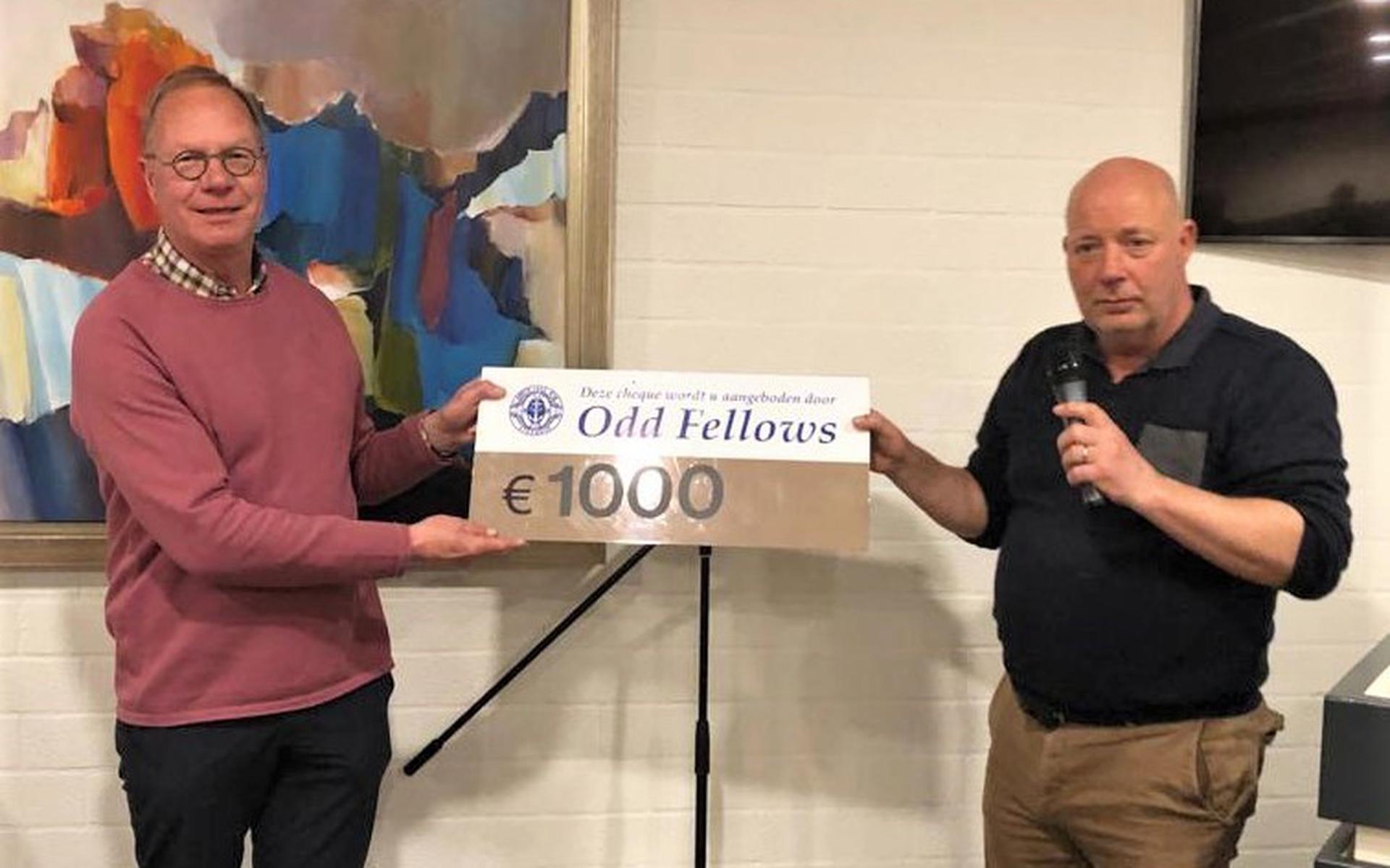 Wim Hultink (links) neemt namens Stichting Present de cheque in ontvangst die overhandigd wordt door Michiel Draaisma namens de Odd Fellows.
