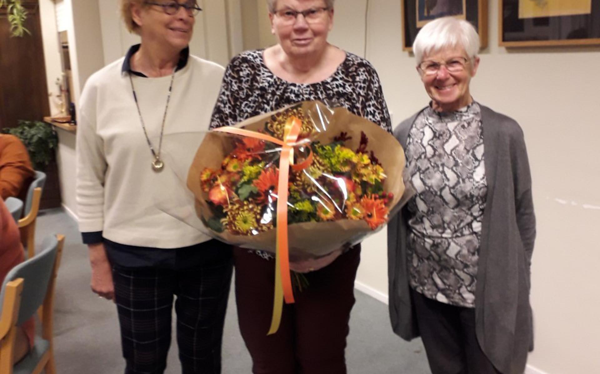 Hennie Meijering kreeg een grote bos bloemen bij haar afscheid als vrijwilliger van de Zonnebloem afdeling Giethoorn/Wanneperveen. Links van haar voorzitter Anneke Koopmans en rechts, secretaris Lammie Maat.