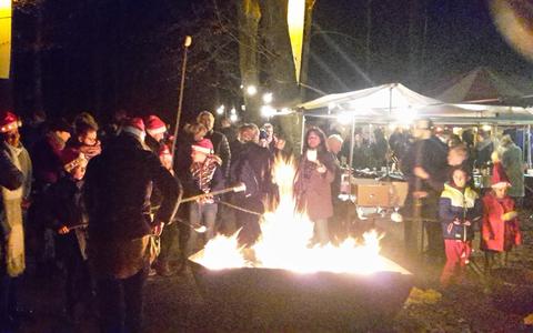 Opwarmen bij het kampvuur tijdens de Mystieke Kerstwandeling in het Kuinderbos.