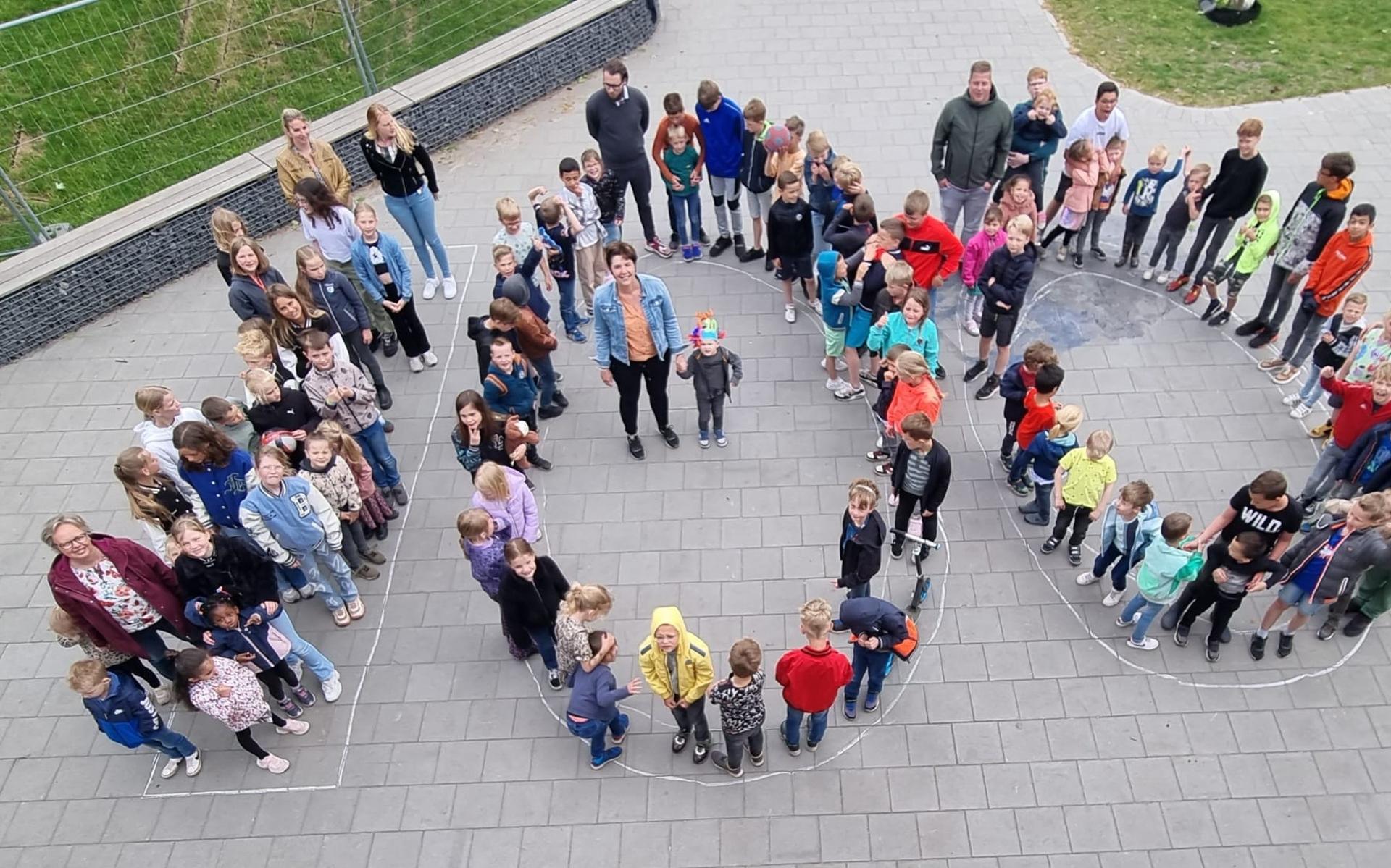 Thijs Smook, in het midden samen met directeur Jacqueline Driezen, is de 100ste leerling op basisschool 't PuzzelsTuk