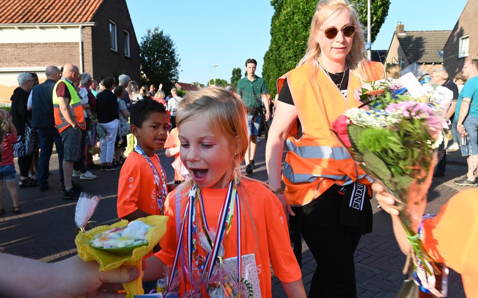 De jonge wandelaars worden overladen met snoep en bloemen bij de binnenkomst in Sint Jansklooster.