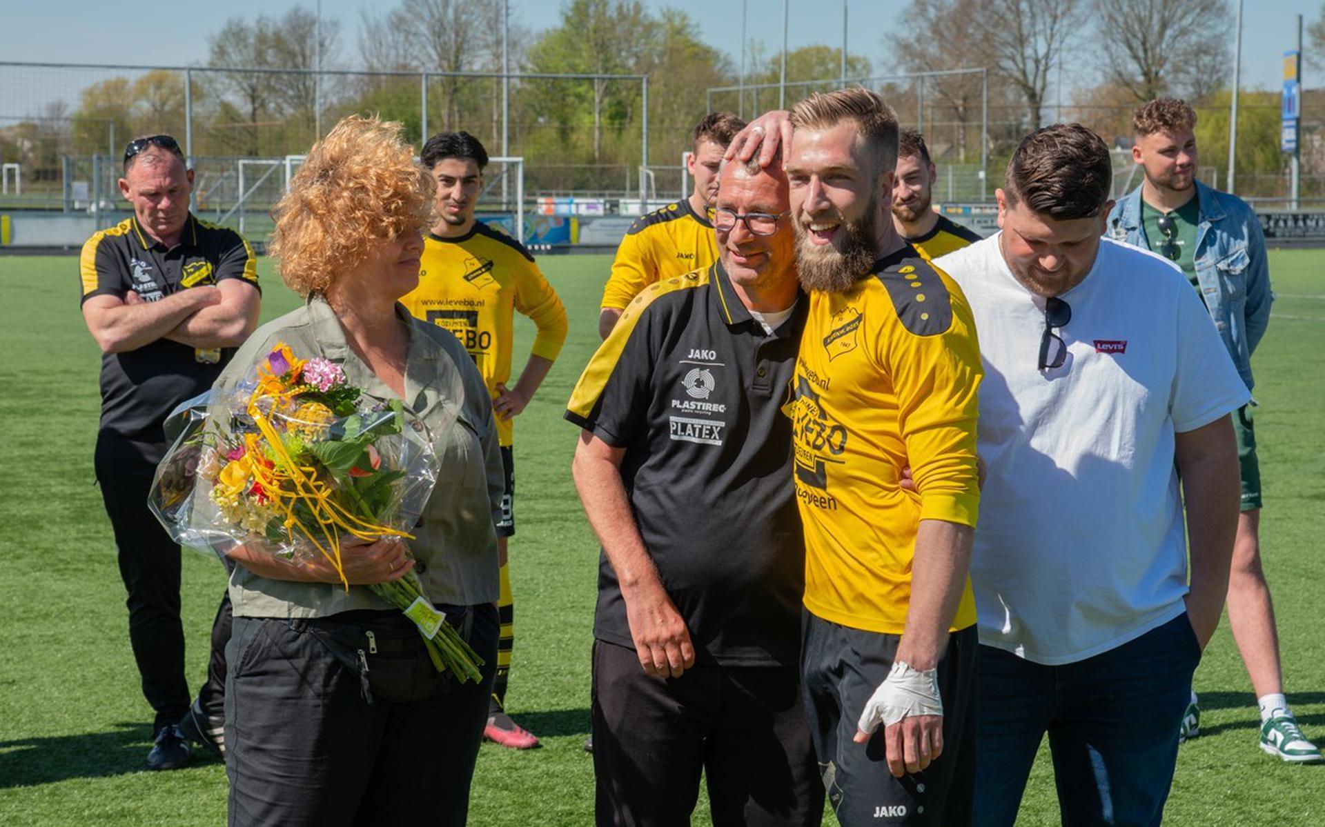 Mede-trainer en -speler Jarno Muis knuffelt Jan Boxum, onder het toeziend oog van Boxums vrouw Angelique en hun zoon Jari.