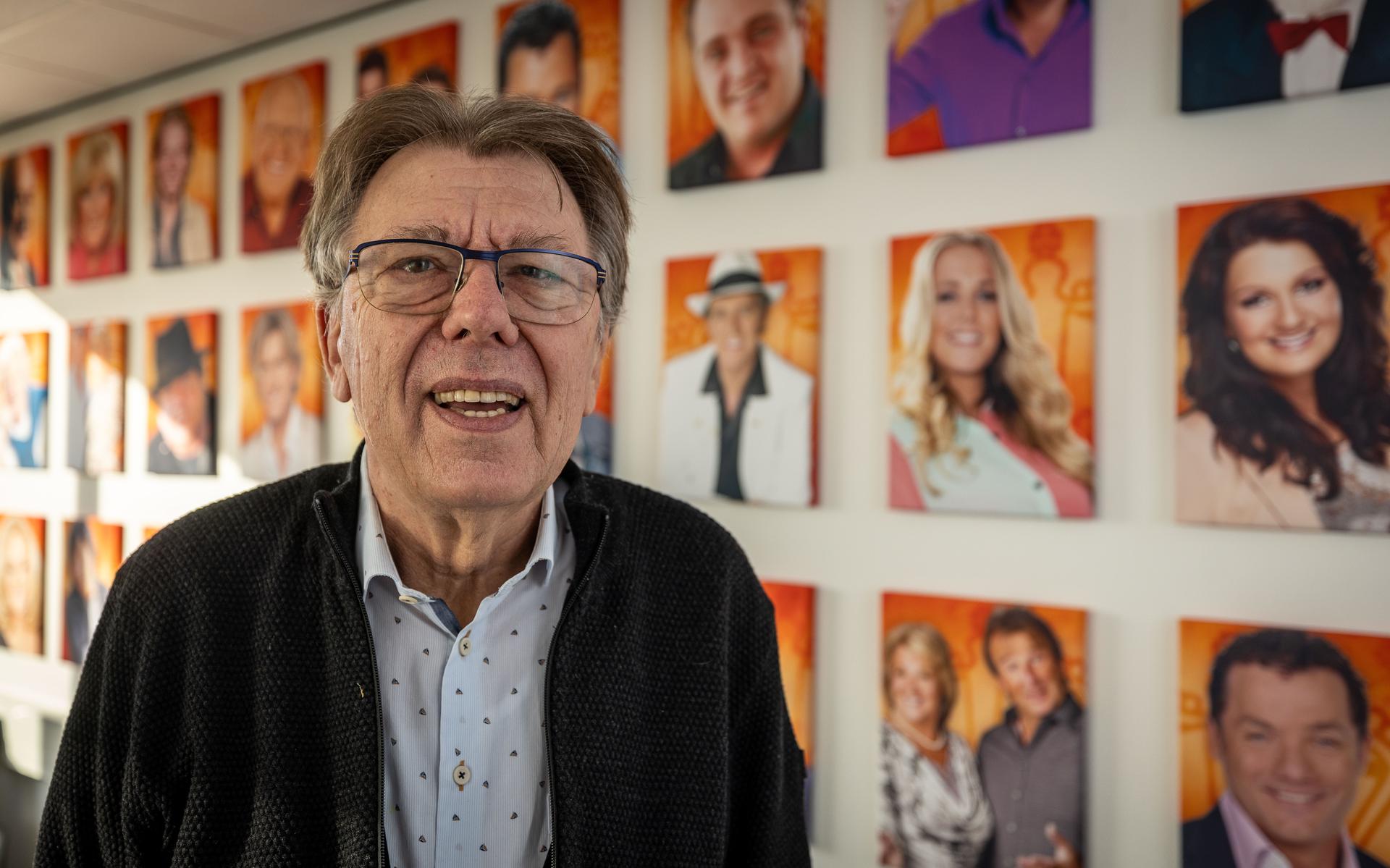 Directeur Gerard Ardesch bij een fotocollage van Nederlandstalige zangers en zangeressen.