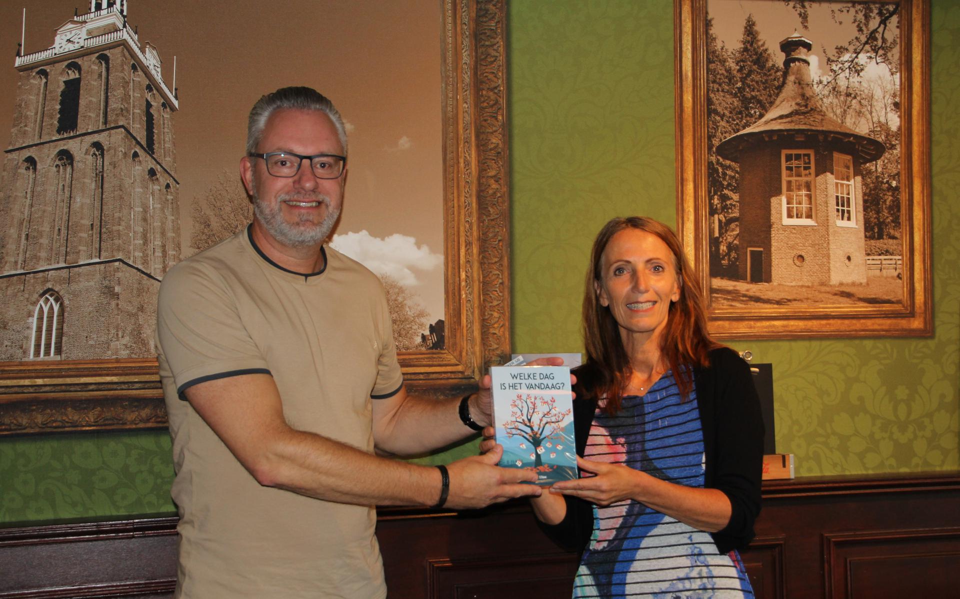 Rina Stam overhandigt het boek aan Rolf Kuizenga.