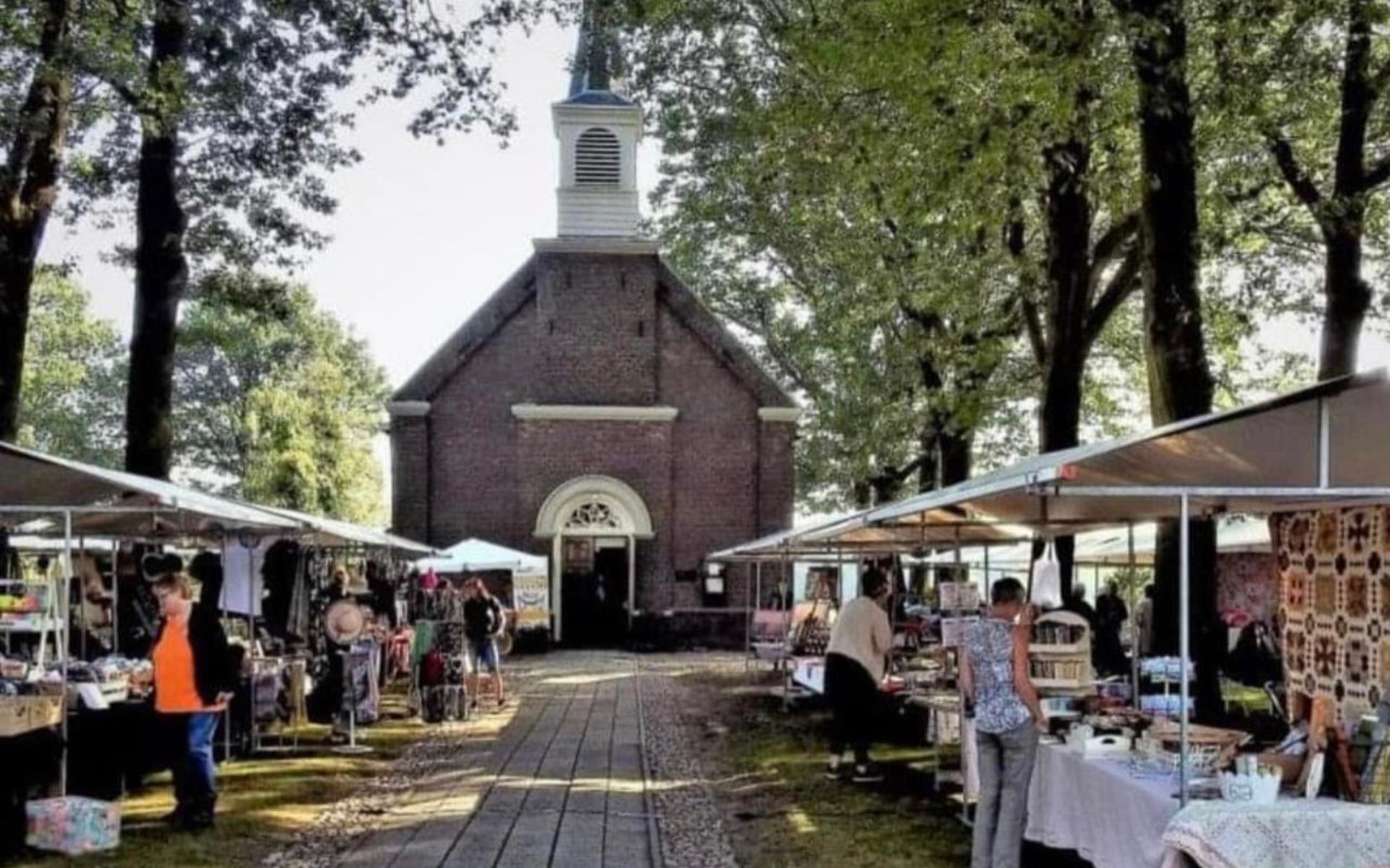 De markt is opgesteld op het terrein voor de Koloniekerk. 