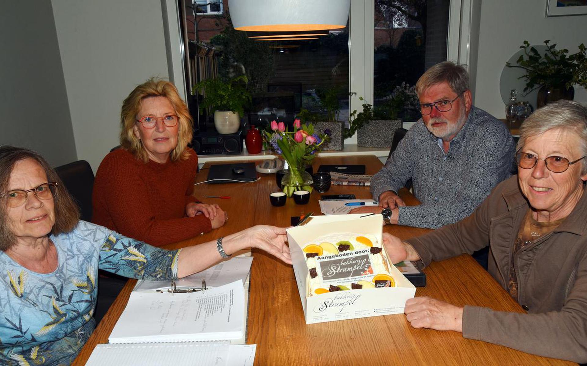 Bestuursleden Janny de Vries, Joke van der Heide, Gert Veld en Linda Wibbelink zijn blij verrast met de taart. 